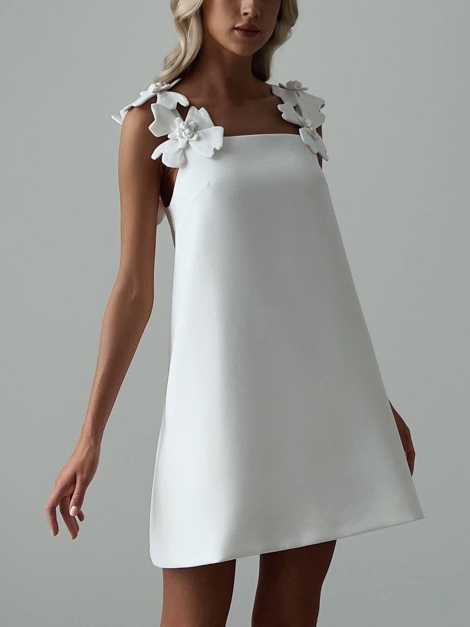 Elegant White Mini Dress with Floral Shoulder Detail.