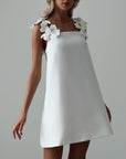 Elegant White Mini Dress with Floral Shoulder Detail.