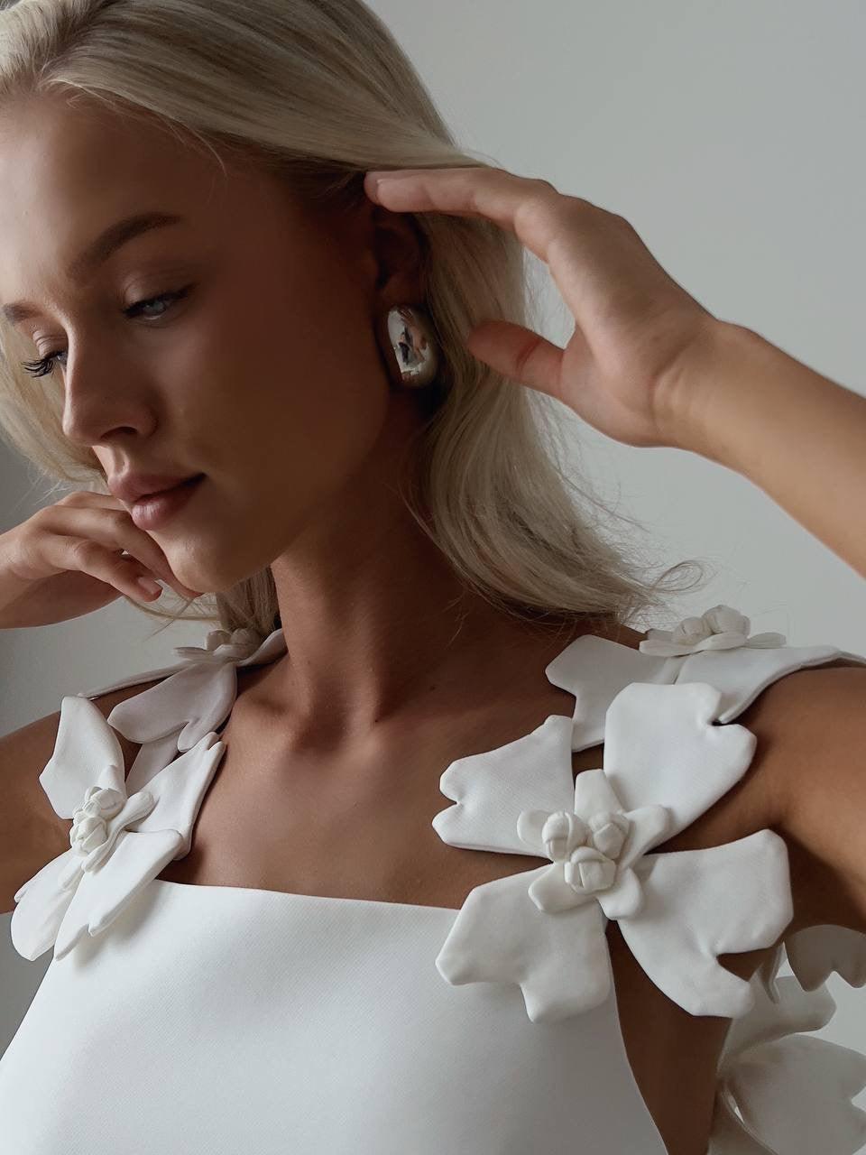 Elegant White Mini Dress with Floral Shoulder Detail.