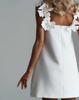 Elegant White Mini Dress with Floral Shoulder Detail.